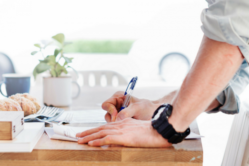 man signing a conveyancing contract